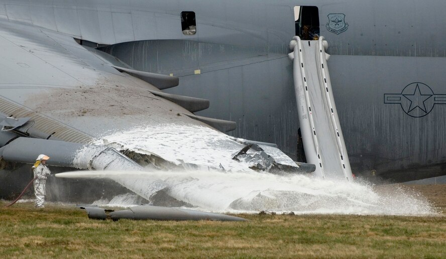 A firefighter hoses down the crash site of a C-5 Galaxy. The aircraft crashed at 6:30 a.m. EDT Monday at Dover Air Force Base, Del., just south of the base flightline. (U.S. Air Force photo/Doug Curran)