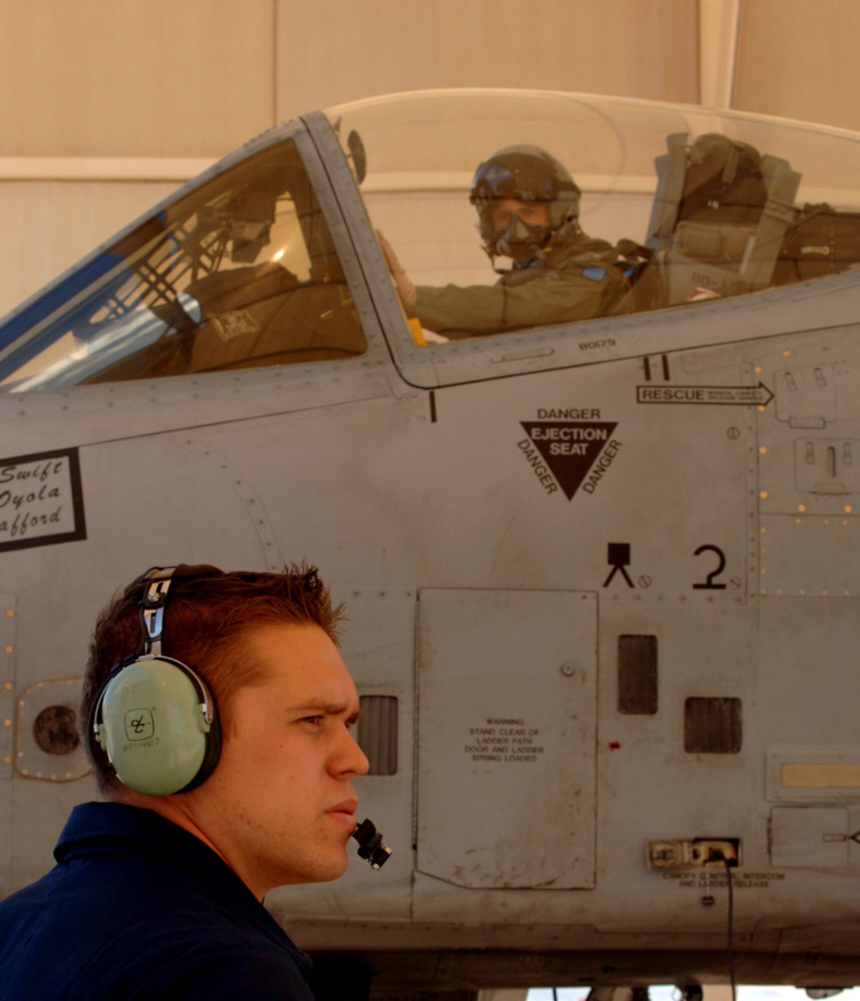 Enclosed in the cockpit of an A-10 Thunderbolt II, Capt. Steve Raspert relies on his crew chief, Airman 1st Class Steve Hachey, on Saturday, April 1, 2006, at Davis-Monthan Air Force Base, Ariz.  Captain Raspert is with the 354th Fighter Squadron; Airman Hachey is with the 355th Aircraft Maintenance Squadron.  (U.S. Air Force photo/Staff Sgt. Lanie McNeal)