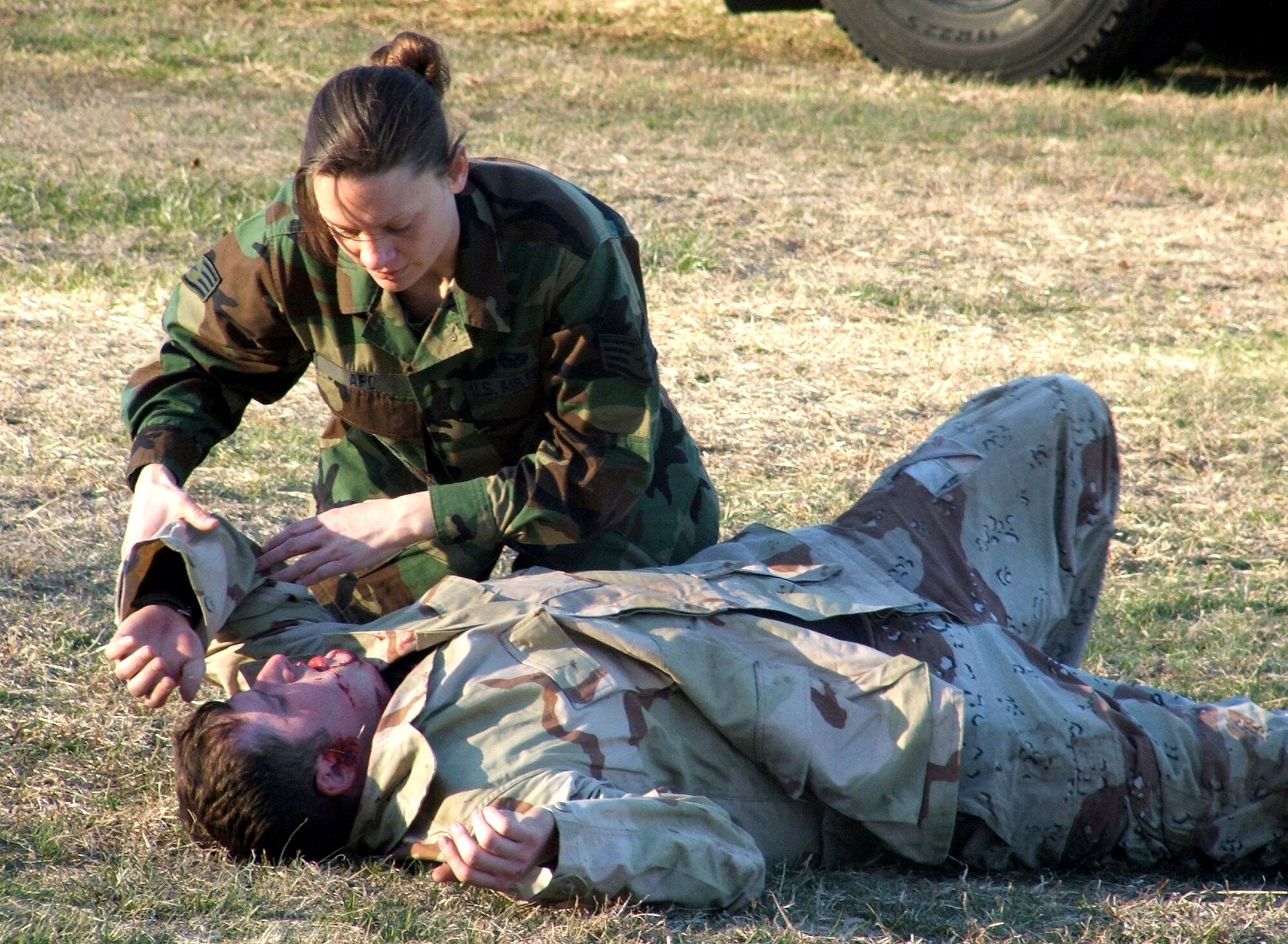 Staff Sgt. April Apo assists a "victim" injured by a simulated "bomb" during combat first aid training at the Air Force Phoenix Raven Course 06-D, on Monday, March 27, 2006.  She is one of 24 students attending the course taught by the Air Mobility Warfare Center's 421st Combat Training Squadron.  Sergeant Apo is with the Nevada Air National Guards 152nd Security Forces Squadron at Reno-Tahoe International Airport, Nev. (U.S. Air Force photo/Tech. Sgt. Scott T. Sturkol)