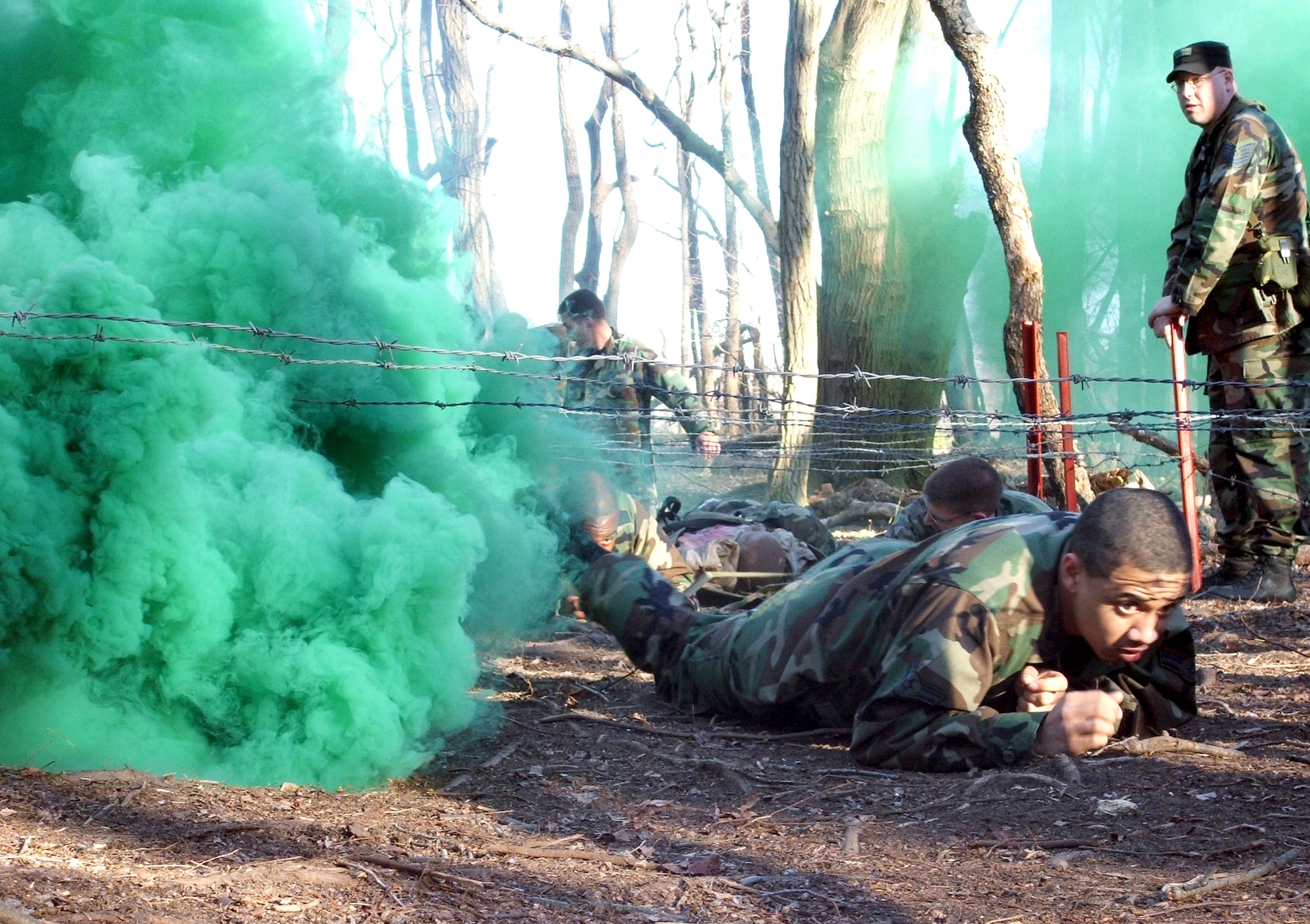 Airman 1st Class Brian Conlee crawls under wire during combat first aid training at the Air Force Phoenix Raven Course 06-D on Monday, March 27, 2006, at Fort Dix, N.J. The students include Air Force security forces and U.S. Navy masters at arms personnel. They are trained in combat first aid, tactical self defense and aircraft security and undergo extensive physical training.  The course is taught by the Air Mobility Warfare Center's 421st Combat Training Squadron. Airman Conlee is with the 62nd Security Forces Squadron at McChord Air Force Base, Wash. (U.S. Air Force photo/Tech. Sgt. Scott T. Sturkol)