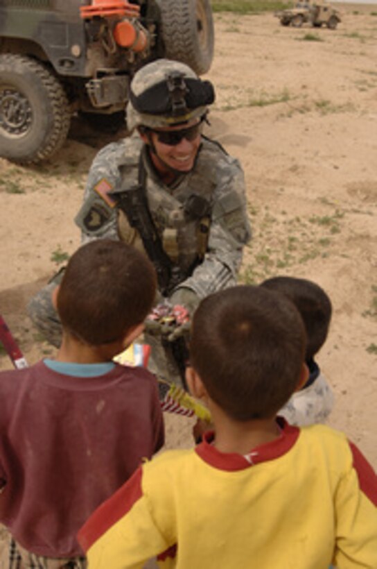 U.S. Army Capt. Michael Wiser offers candy to Iraqi children in a village outside Tikrit, Iraq, during a goodwill visit on April 1, 2006. Soldiers from the 4th Battalion, 101st Aviation Regiment, Contingency Operating Base Speicher, are distributing donated items from U.S. citizens for the Iraqis. 
