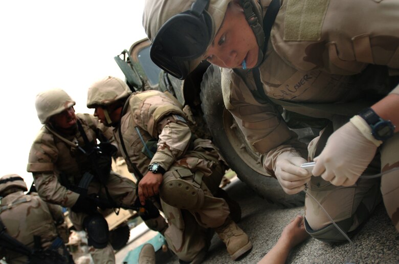 Senior Airman Rachel Cover prepares to insert an IV into a simulated convoy casualty during the Basic Combat Convoy Training course at Camp Bullis, Texas, on Monday, April 3, 2006. The course is designed to keep Airmen battlefield focused and well-trained for convoy operations.  (U.S. Air Force photo/Tech. Sgt Cecilio Ricardo Jr.)