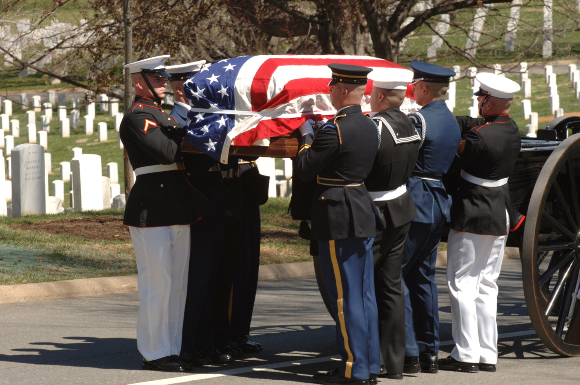 A Joint Service ceremonial guard team  removes from the caisson the casket containing former Secretary of Defense Caspar Weinberger at the gravesite in Arlington National Cemetery, Arlington, Va., April 4, 2006.  Secetary Donald H. Rumsfeld delivered remarks during the memorial service.  (U.S. Air Force photo by Airman 1st Class Timothy S. Chacon)
