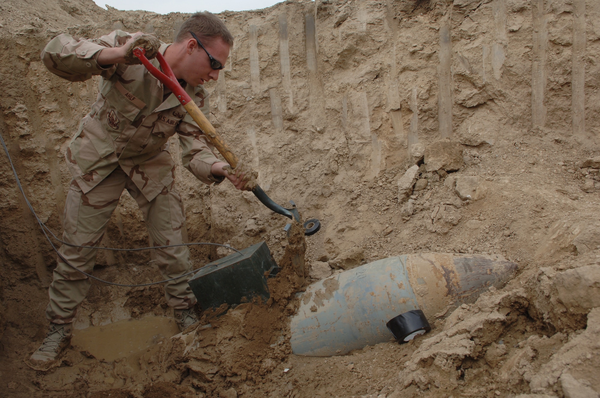 Senior Airman Cory Ahlf shovels mud to help hold an ammo can covering a C-4 explosive charge in place at Bagram Air Base, Afghanistan, on Thursday, March 30, 2006. Airman Ahlf is assigned to the 755th Expeditionary Mission Support Group as an explosive ordnance disposal journeyman. He is deployed from F.E. Warren Air Force Base, Wyo. (U.S. Air Force photo/Staff Sgt. Jennifer Redente)