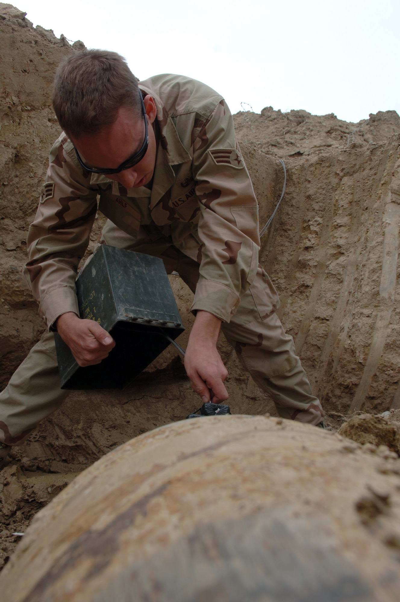 Senior Airman Cory Ahlf places blasting caps into C-4 explosive to dispose of an unexploded 1,100-pound Russian bomb found 200 feet from the runway at Bagram Air Base, Afghanistan. Airman Ahlf is assigned to the 755th Expeditionary Mission Support Group as an explosive ordnance disposal journeyman. He is deployed from F.E. Warren Air Force Base, Wyo. (U.S. Air Force photo/Staff Sgt. Jennifer Redente)