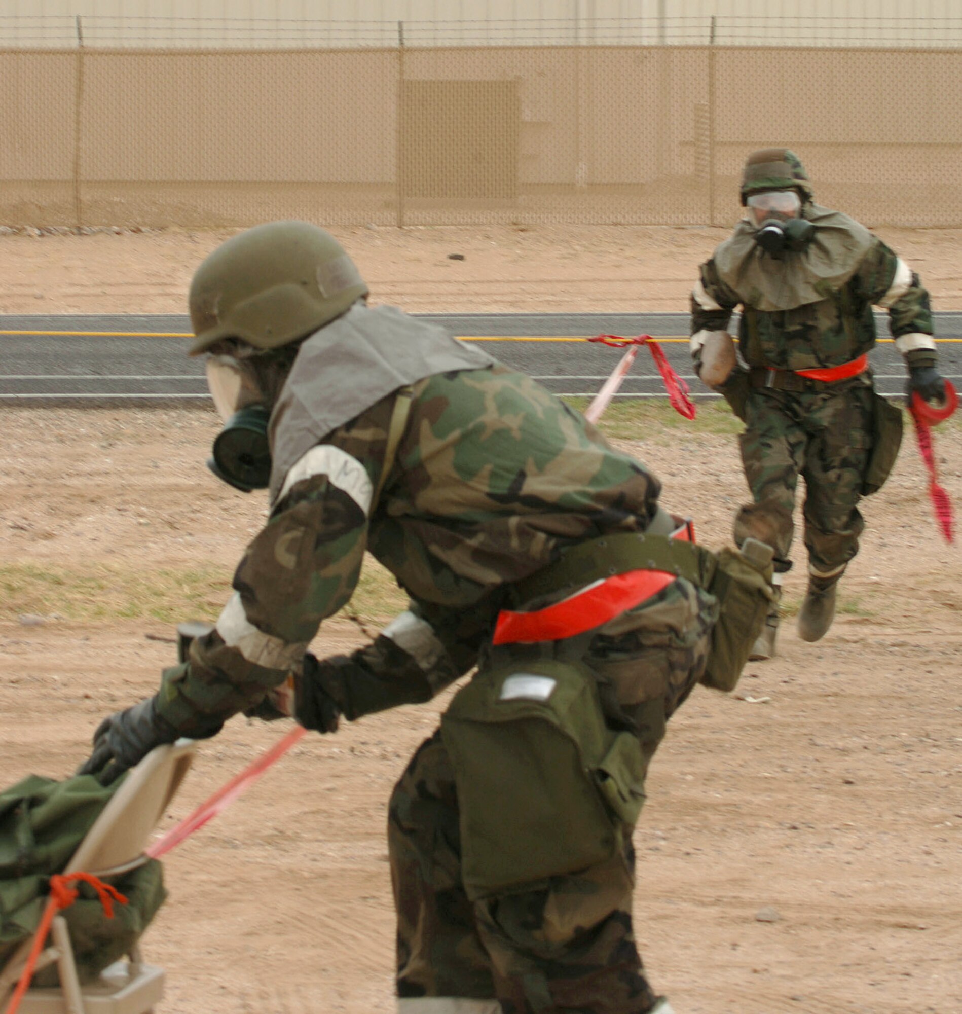 Tech. Sgt. Mark McKay and Staff Sgt. Rodney Jeter-Hicks cordon off the area where a simulated bomb is located during an exercise at a simulated deployed location on Tuesday, April 4, 2006. (U.S. Air Force photo/Staff Sgt. Lanie McNeal)