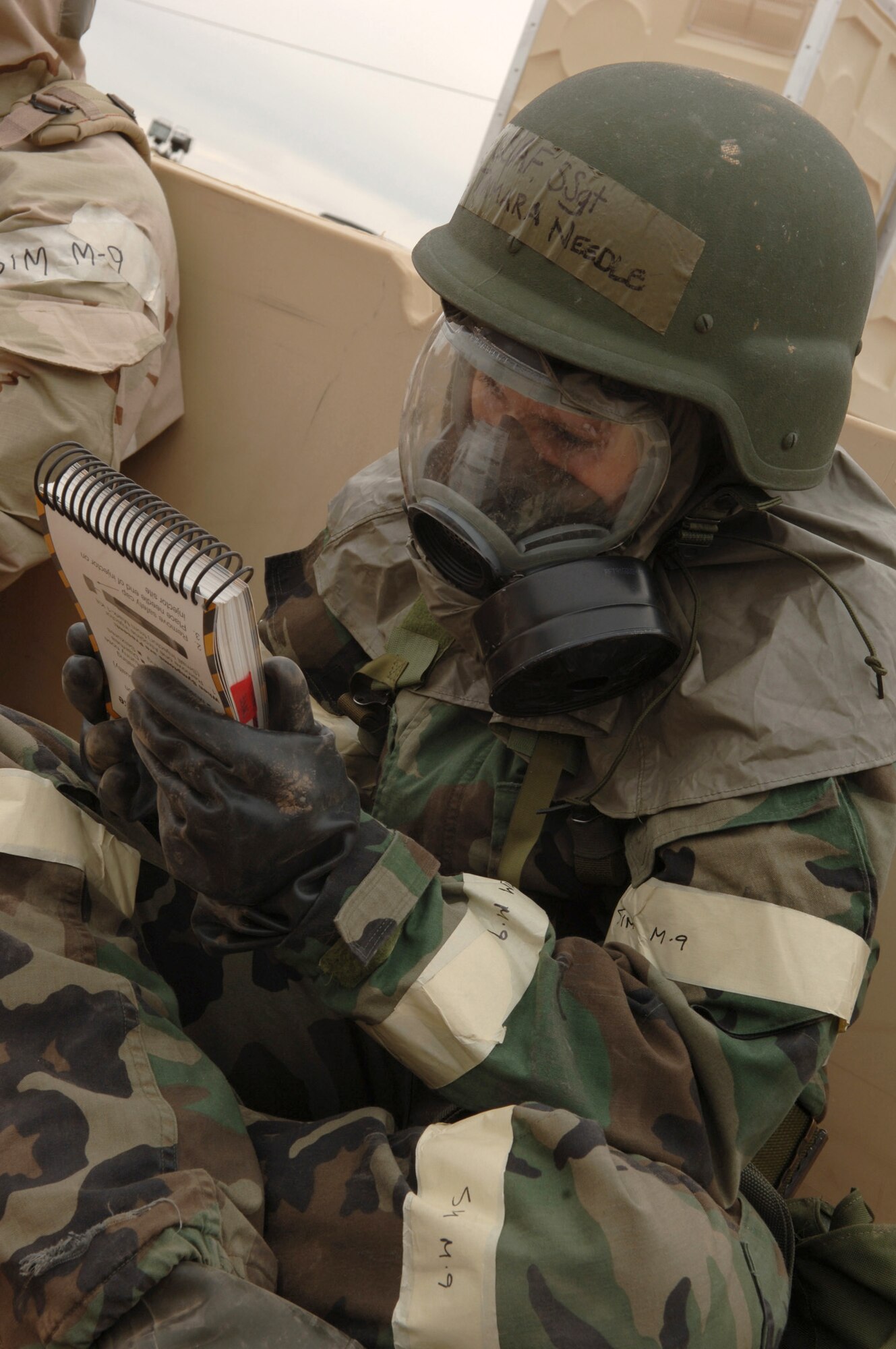 Staff Sgt. Tamara Needle studies her Airman's manual as she takes cover in an improvised bunker during an exercise at a simulated deployed location on Tuesday, April 4, 2006.  Sergeant Needle is with the 355th Communications Squadron.  (U.S. Air Force photo/Staff Sgt. Lanie McNeal)