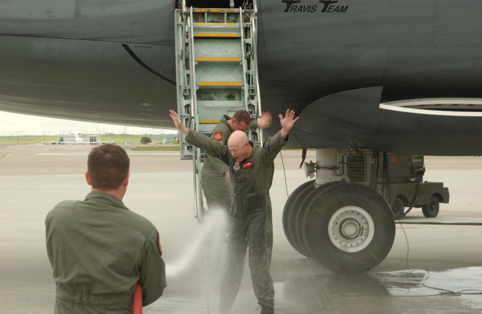 An Airman drenches C-5 crew members with a fire hose March 31 as they exit from the aircraft. The 10-member crew was returning from the final C-5 flight for the 21st Airlift Squadron. The 21st AS officially transitioned from a C-5 squadron to a C-17 squadron in a ceremony here April 3. The day also marked the squadron’s 64th anniversary. (U.S. Air Force photo by Luther Tolliver)