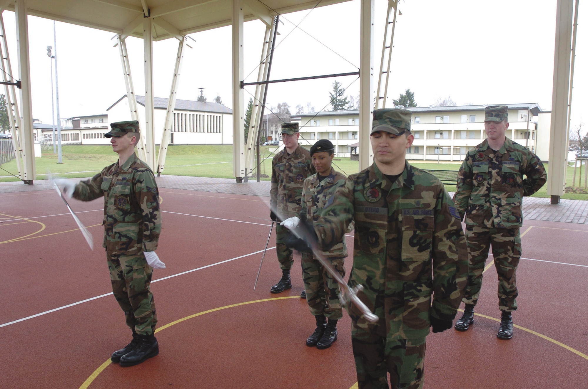 Staff Sgt. Ernesto Otero, 52nd Fighter Wing honor guard NCOIC, prepares to catch a spinning saber while base honor guard members Senior Airman Josh Vanderbeck and Airman 1st Class Jacob McCarty, and U.S. Air Force Academy Saber Drill Team Cadet 1st Class Rhoshonda McGruder practice their drill routine here Wednesday.