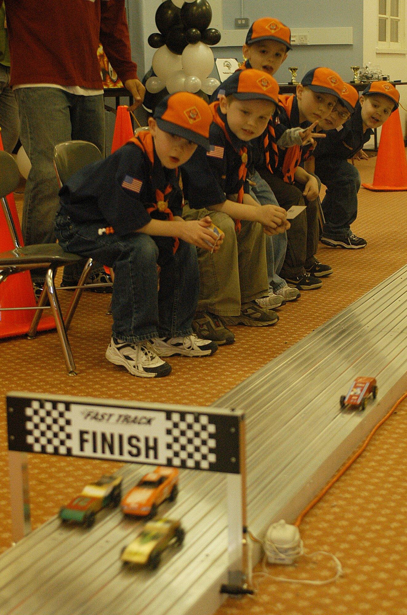 Boy Scouts watch their pinewood cars fly down the metal track, past the tracking system, which displays their place number and hit the foam inertia disruption device at RAF Feltwell Saturday.  