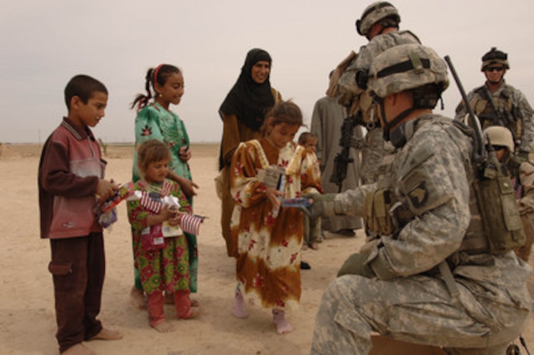 Soldiers from the U.S. Army's 4th Battalion, 101st Aviation Regiment hand out small American flags and gifts to children during a goodwill visit to a village outside of Tikrit, Iraq, on April 1, 2006. The items were donated by U.S. citizens to distribute to Iraqi citizens. 
