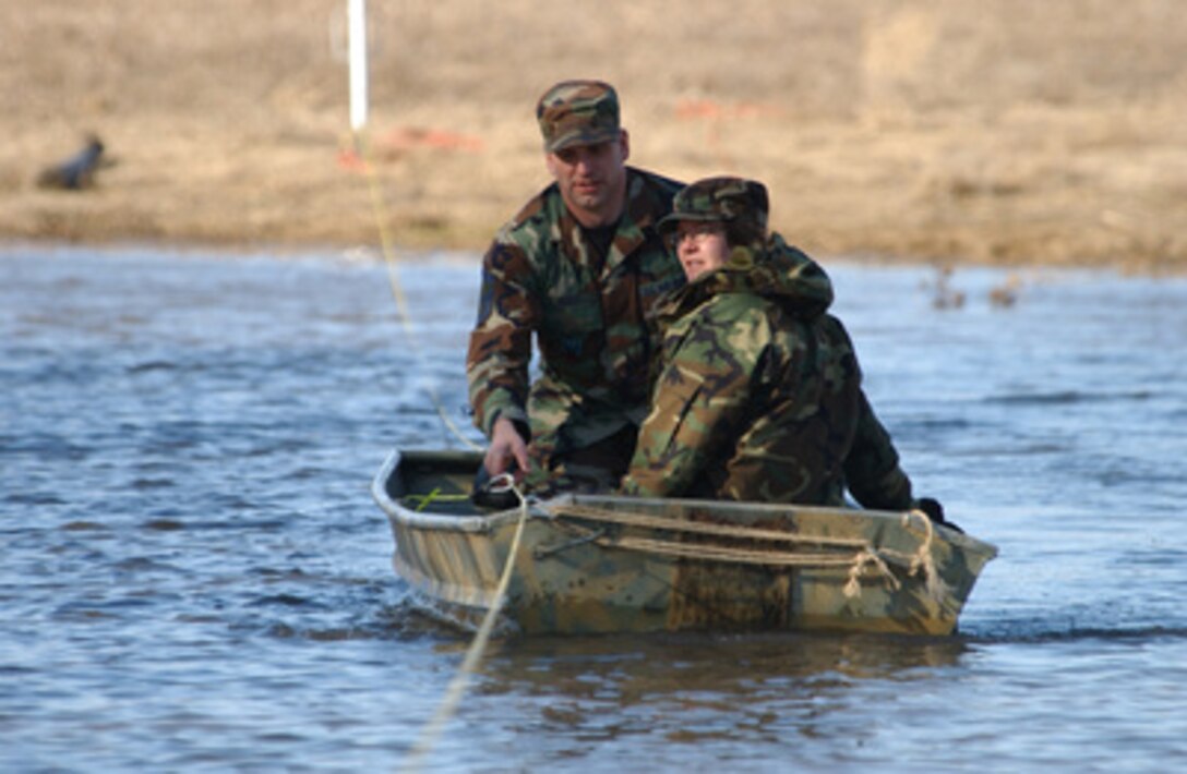 U.S. Air Force Senior Master Sgts. Brian D. Rust and Kathy A. Rust use a boat to commute to work at the North Dakota Air National Guard in Fargo, N.D., on April 3, 2006, after the rising Wild Rice River flooded the roads near their home. Both are attached to the 119th Fighter Wing in Fargo. 