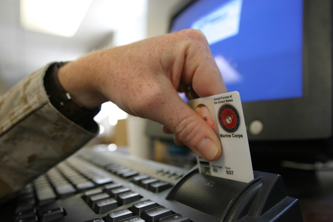 MARINE CORPS BASE CAMP LEJEUNE, N.C. (April 6, 2006) ? A Marine places his Common Access Card into a modified card-reading keyboard here April 6. The card will be read through the computer and allow Marines with 2nd Marine Logistics Group to attach an electronic signature to documents they send through their government e-mail accounts. Although the capabilities have been there since 2003, the year the CAC replaced its predecessor, the Smart Card, many servicemembers have not used their cards for anything other than as a form of identification.