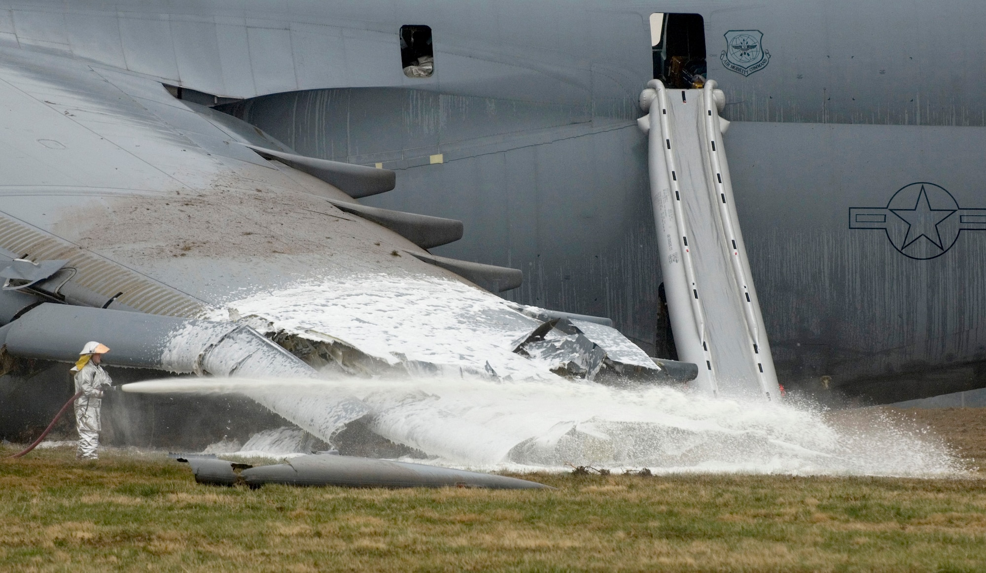 A firefighter hoses down the crash site of a C-5 Galaxy. The aircraft crashed at 6:30 a.m. EDT, on Monday, April 3, 2006, at Dover Air Force Base, Del., just south of the base flightline. All 17 people aboard survived the crash.  (U.S. Air Force photo/Doug Curran)