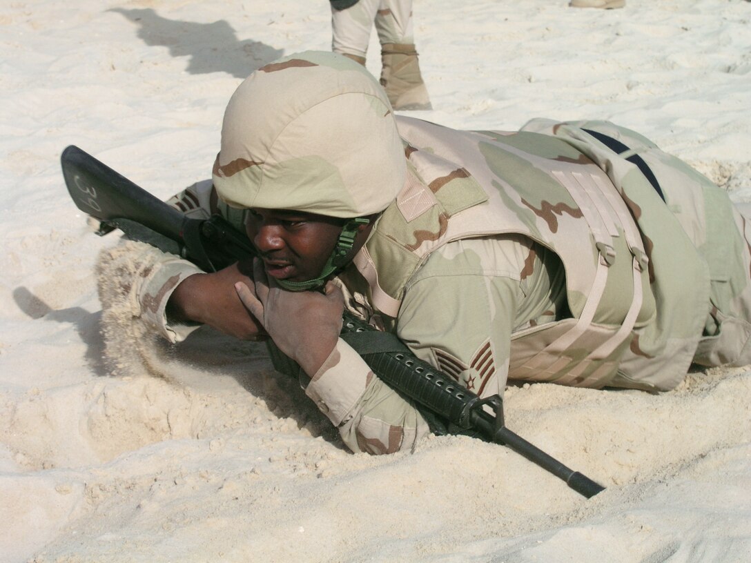 Staff Sgt. Kevin Suggs low-crawls through sand during a ground combat skills exercise. During the exercise, Airmen learned a variety of defensive maneuvers traditionally reserved for security forces members at desert base recently. Sergeant Suggs is assigned to the 64th Air Expeditionary Group at a forward-deployed location. (U.S. Air Force photo/Col. Jay Carlson)