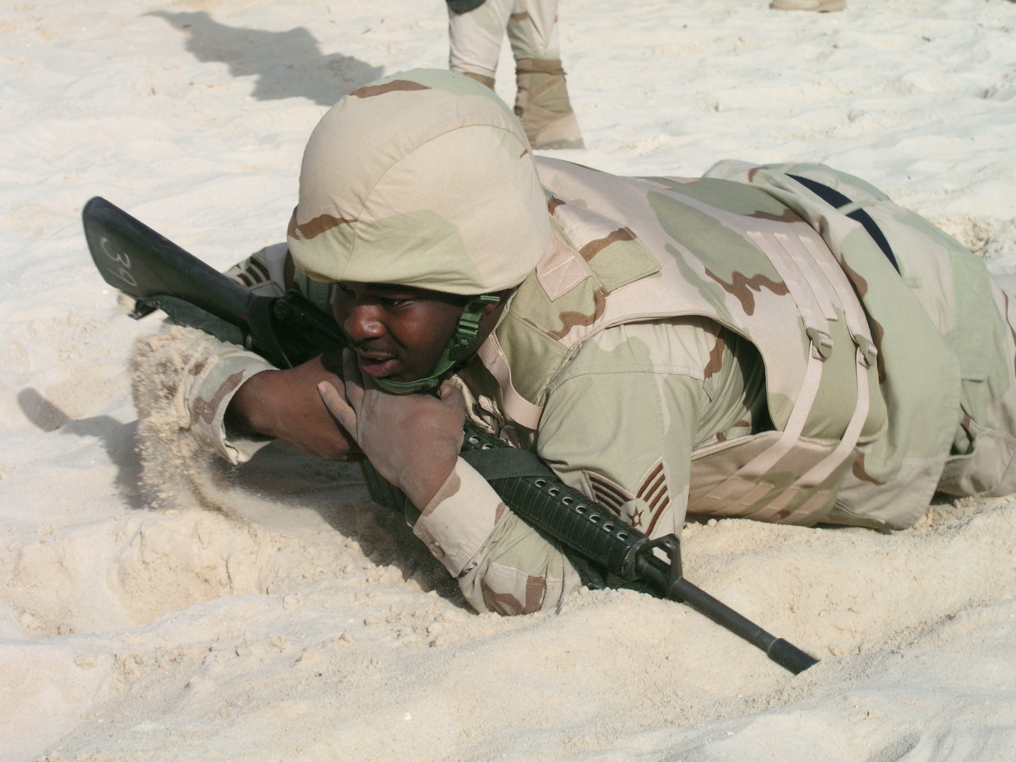 Staff Sgt. Kevin Suggs low-crawls through sand during a ground combat skills exercise. During the exercise, Airmen learned a variety of defensive maneuvers traditionally reserved for security forces members at desert base recently. Sergeant Suggs is assigned to the 64th Air Expeditionary Group at a forward-deployed location. (U.S. Air Force photo/Col. Jay Carlson)

