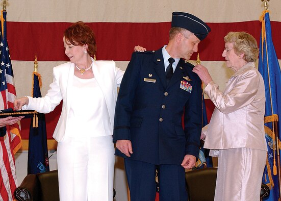 MCCHORD AIR FORCE BASE, Wash., - Beth Crabtree, left, and Ruth Crabtree right, pin on Brig. Gen. Eric Crabtrees stars during his promotion ceremony April 1.  General Crabtree is the commander of the 446th Airlift Wing.             