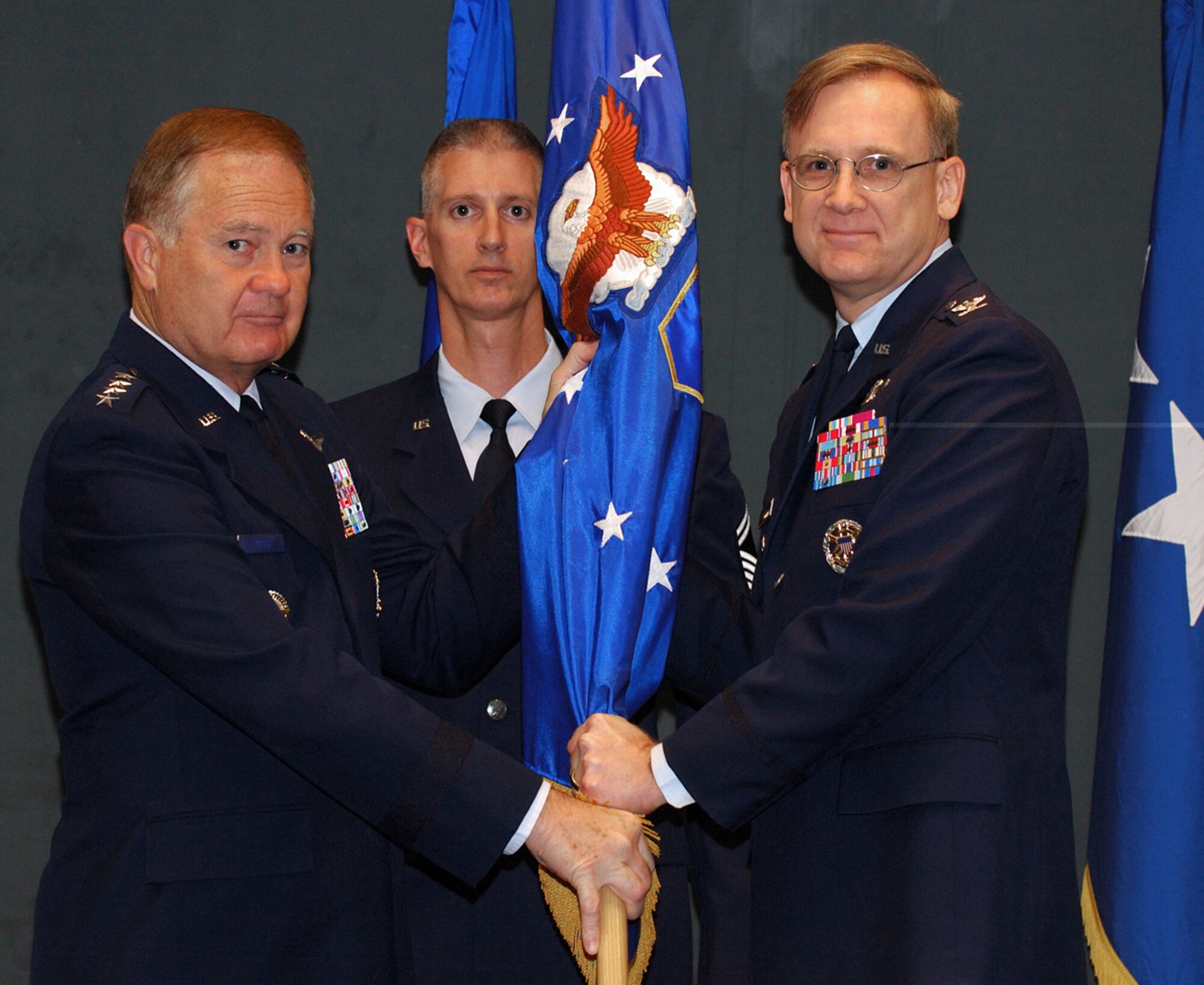 Col. Brian T. Kelly assumes command of the Air and Space Expeditionary Force Center from General Ronald E. Keys, Commander, Air Combat Command, as Senior Master Sgt. Craig A. Fitzkee looks on.