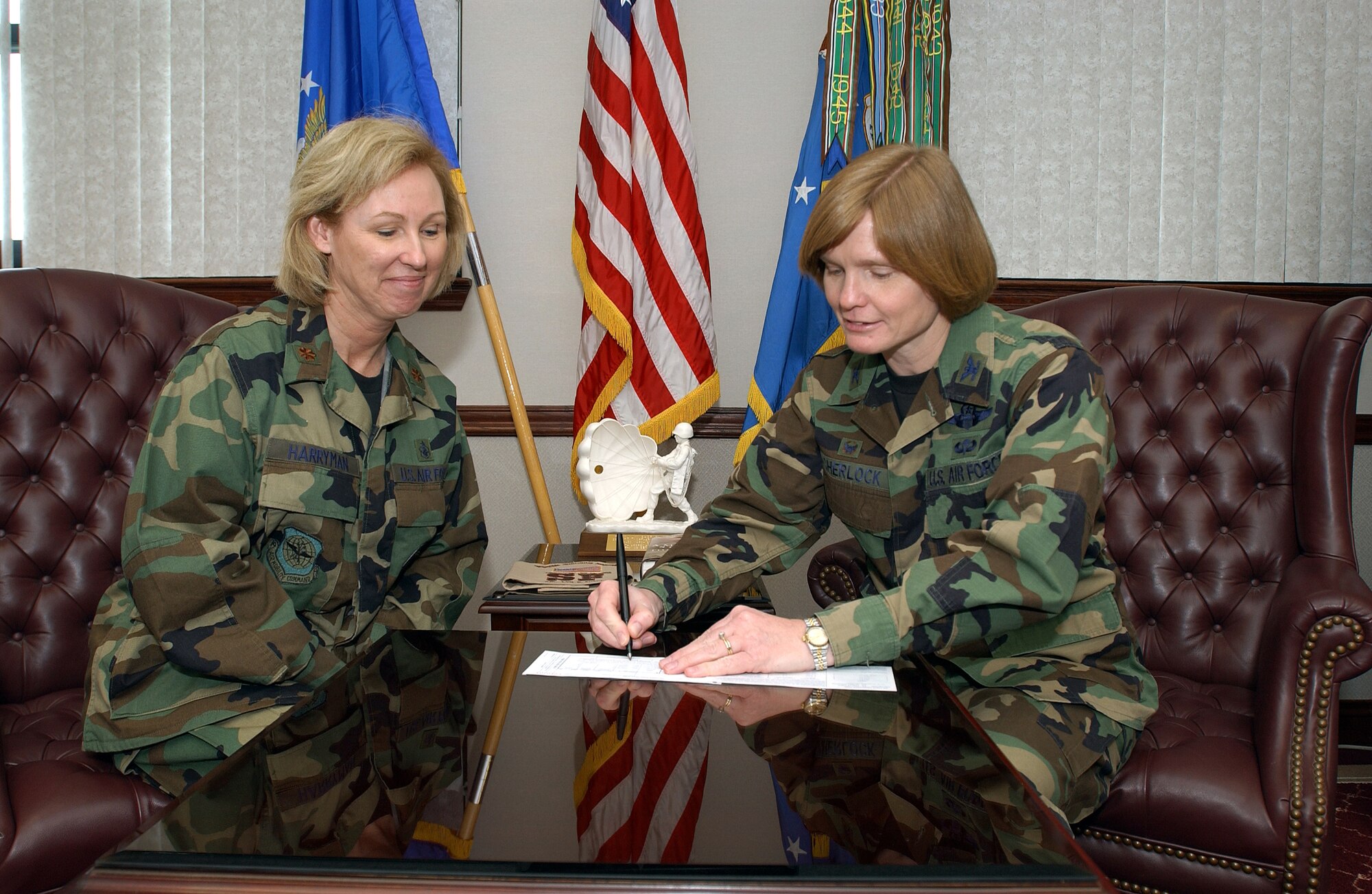 Maj. Kenny Harryman, Air Force Assistance Fund project officer here, looks on while Col. Lyn Sherlock, 60th Air Mobility Wing commander, signs her pledge for this year’s AFAF campaign. The campaign kicked off March 24 and runs through May 4. (U.S. Air Force photo by Andre Mansour)