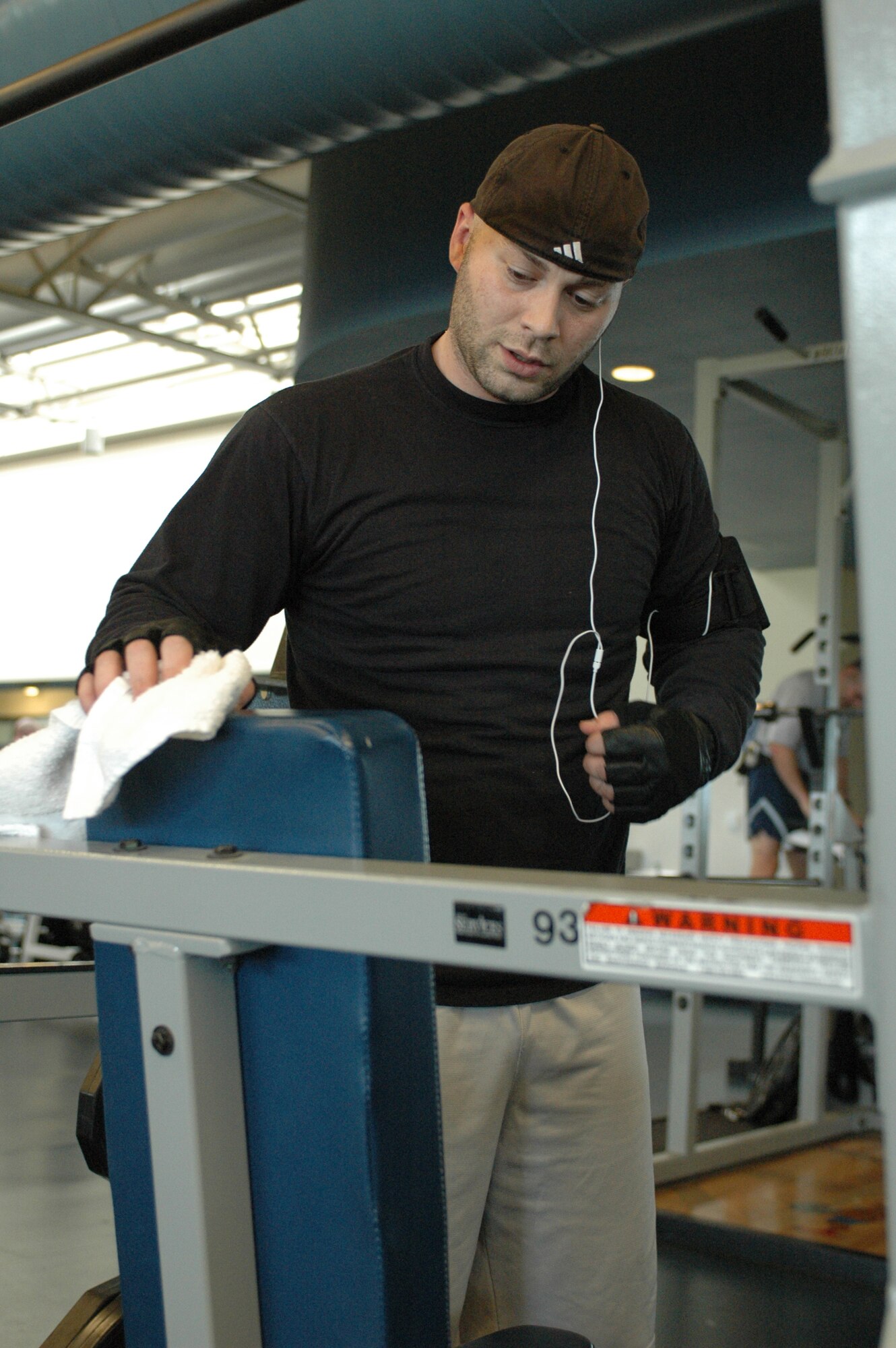 Staff Sgt. Jeffrey Mitchell, 60th Communications Squadron, wipes down a piece of equipment after using it.  Patrons of the Fitness Center are encouraged to wipe down all equipment they use during their workout. (U.S. Air Force photo by Staff Sgt. Raymond Hoy)