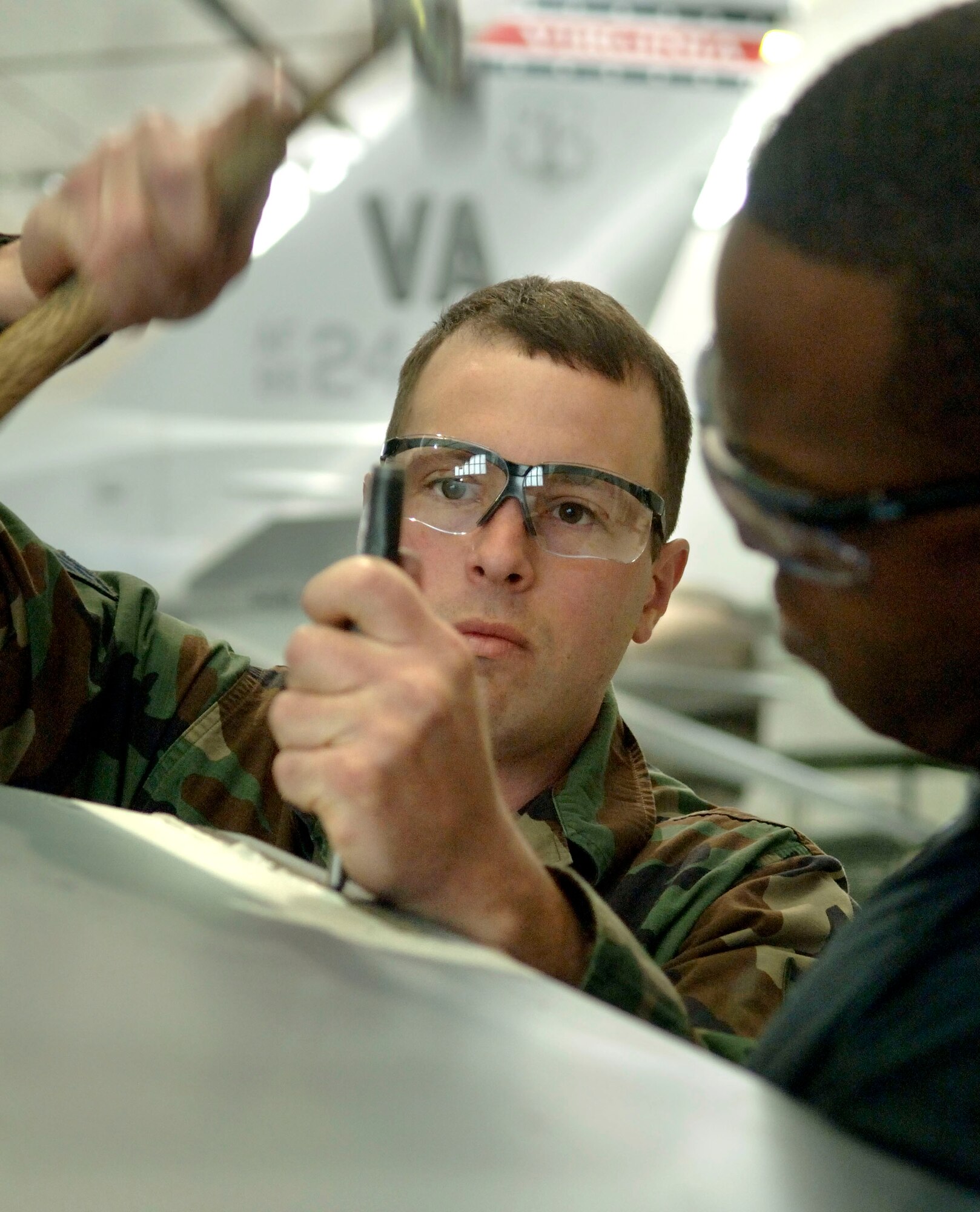 Staff Sgts. Robert McCormick and Jonny Deloach repair the trailing edge of an F-16 Fighting Falcon horizontal stabilizer at the Virginia Air National Guard located in Sandstone, Va., on Thursday, March 30, 2006.  The Virginia ANG is currently transitioning to the new F-22A Raptor at Langley Air Force Base and will replace the F-16s as early as October 2007.  They are both assigned to the 192 Aircraft Maintenance Squadron.  (U.S. Air Force photo/Tech. Sgt. Ben Bloker)