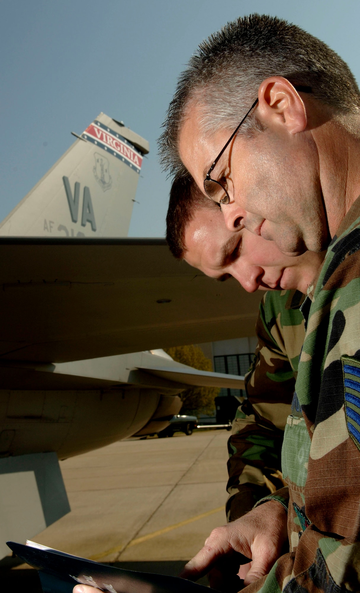 Tech. Sgt. Ricky Barber runs through a checklist during a center-line tank install on an F-16 Fighting Falcon at the Virginia Air National Guard located at Sandstone, Va., on Thursday, March 30, 2006.  Sergeant Barber has served as a crew chief on Tail No. 86219 since 1992.  The Virginia ANG is currently transitioning to the new F-22A Raptor at Langley Air Force Base and will replace the F-16s as early as October 2007. Sergeant barber is with the 192nd Aircraft Maintenance Squadron. (U.S. Air Force photo/Tech. Sgt. Ben Bloker) 