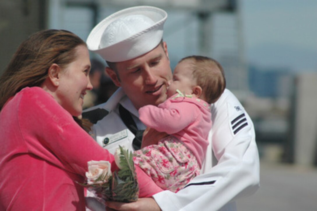 Seaman Brad Murphy takes his new baby girl from his wife's arms after returning to San Diego, Calif., on April 4, 2006. Murphy, a U.S. Navy electrician's mate, was deployed onboard the Los Angeles class submarine USS Topeka (SSN 754). 