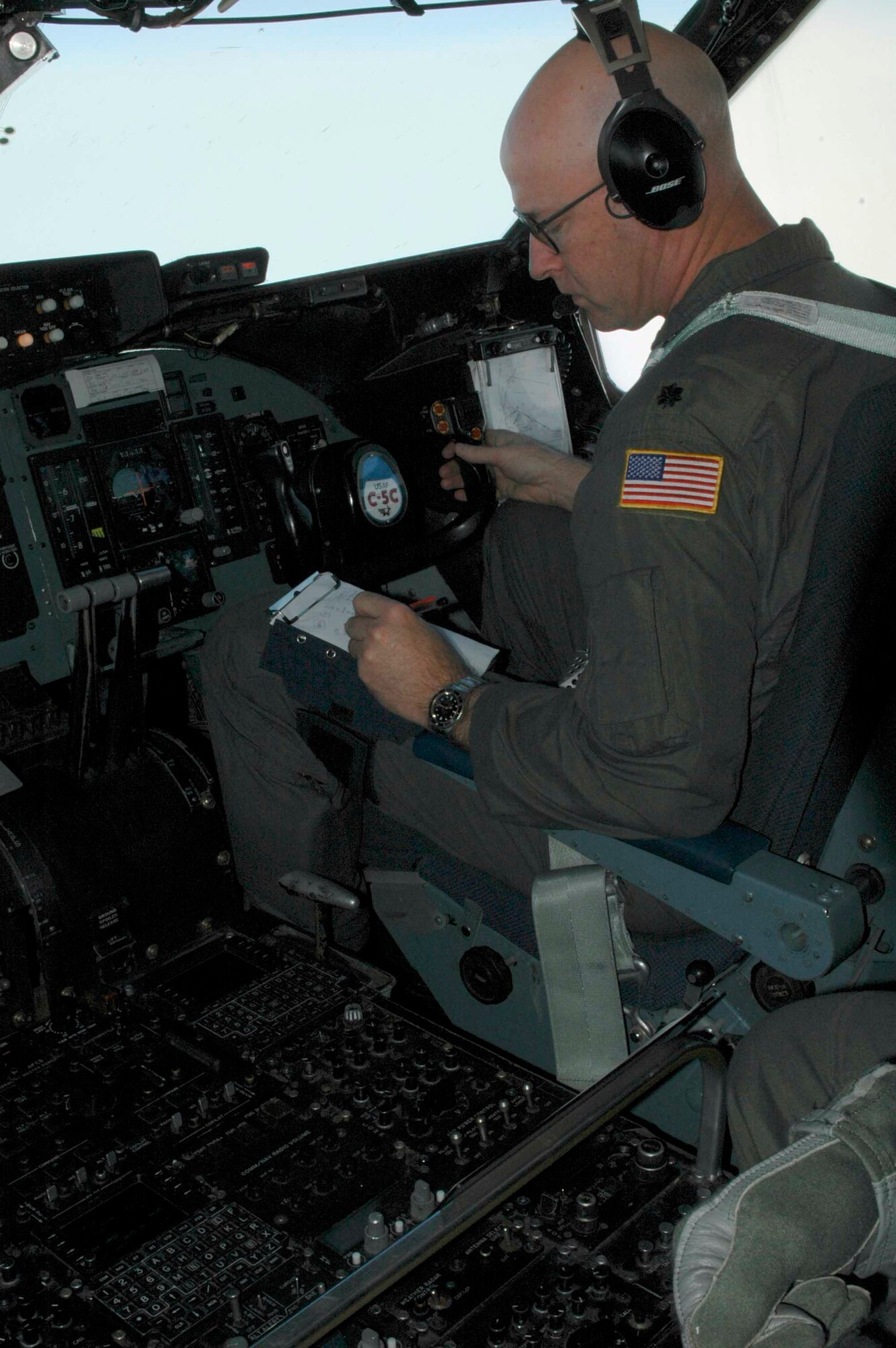 Lt. Col. Bruce Sayre, the mission's aircraft commander, runs checklists during the 21st Airlift Squadron's final C-5 flight March 31. The 21st AS officially transitioned from a C-5 squadron to a C-17 squadron in a ceremony here April 3, which was also the squadron’s 64th anniversary. (U.S. Air Force photo by Airman 1st Class Tiffany Low)