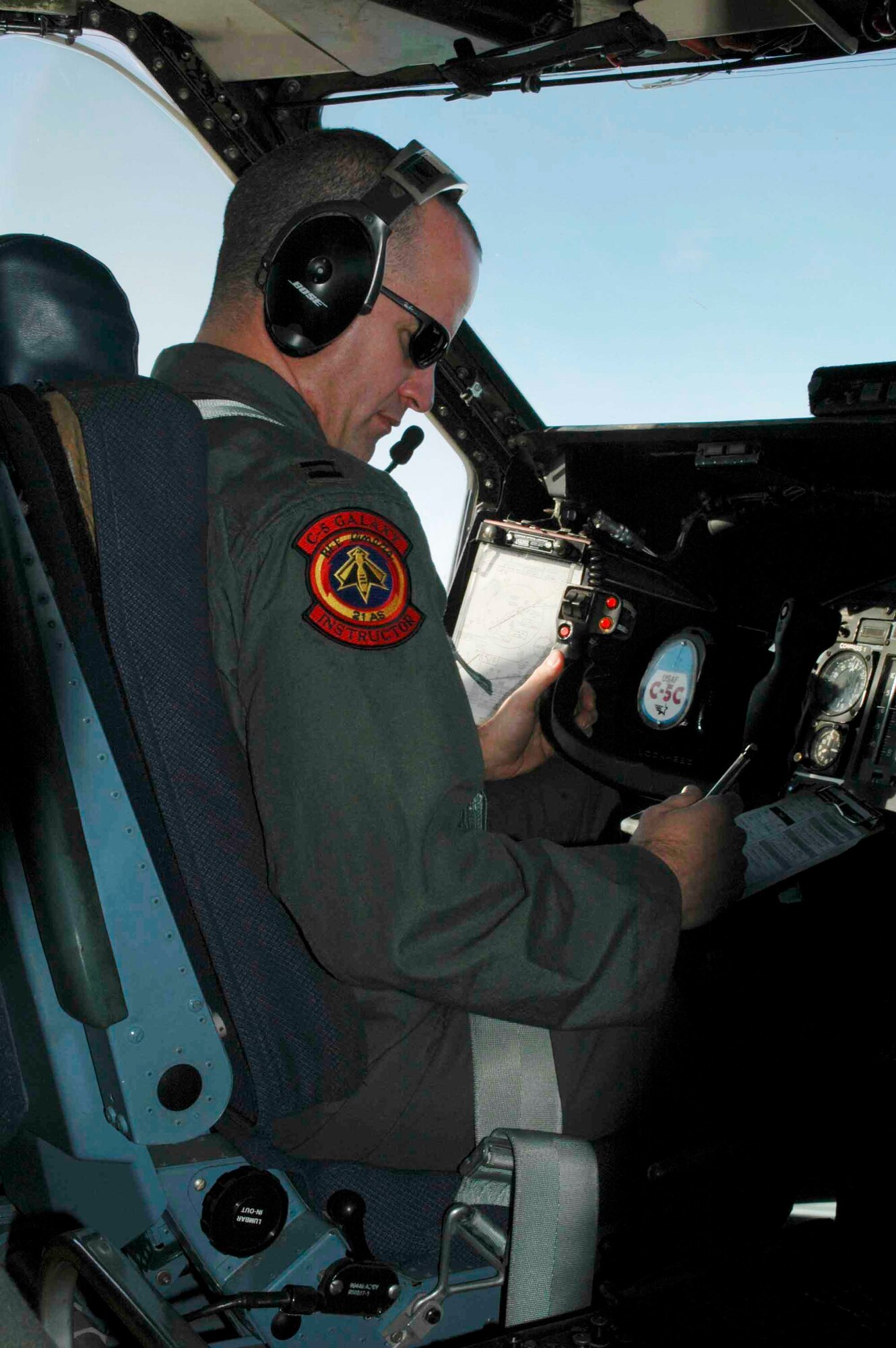 Capt. Robert Prussak, pilot, prepares for air refueling operations by running checklists during the 21st Airlift Squadron's final C-5 flight March 31. The 21st AS officially transitioned from a C-5 squadron to a C-17 squadron in a ceremony here April 3, which was also the squadron’s 64th anniversary. (U.S. Air Force photo by Airman 1st Class Tiffany Low)