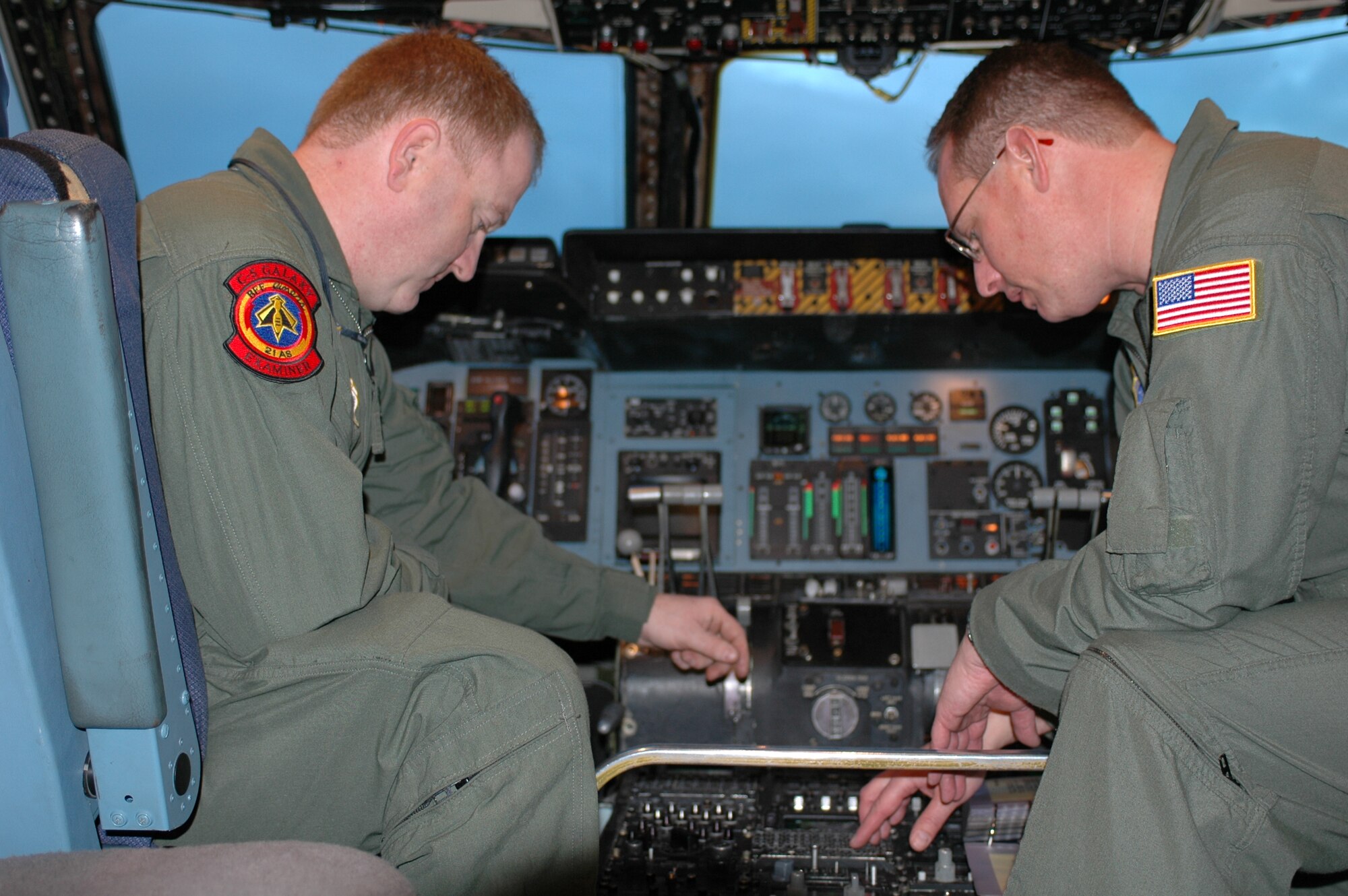 Tech. Sgt. Rolv Ihle, loadmaster, and Master Sgt. Anthony Barber, flight engineer, sets the radio frequencies on VHF and UHF radios prior to the 21st Airlift Squadron's final C-5 flight departure March 31. The 21st AS officially transitioned from a C-5 squadron to a C-17 squadron in a ceremony here April 3, which was also the squadron’s 64th anniversary. (U.S. Air Force photo by Airman 1st Class Tiffany Low)