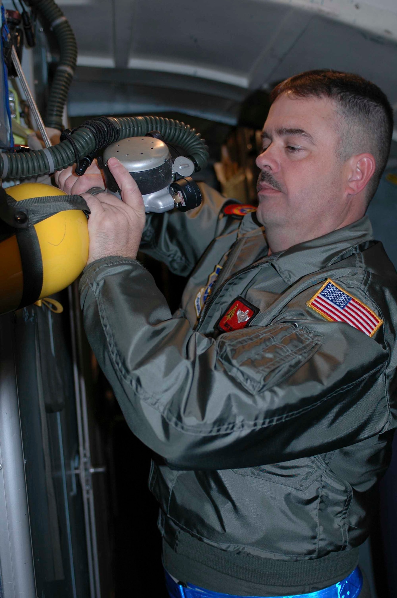 Senior Master Sgt. Richard Larsen, loadmaster, services a portable oxygen bottle prior to the 21st Airlift Squadron's final C-5 flight departure March 31. The 21st AS officially transitioned from a C-5 squadron to a C-17 squadron in a ceremony here April 3, which was also the squadron’s 64th anniversary. (U.S. Air Force photo by Airman 1st Class Tiffany Low)