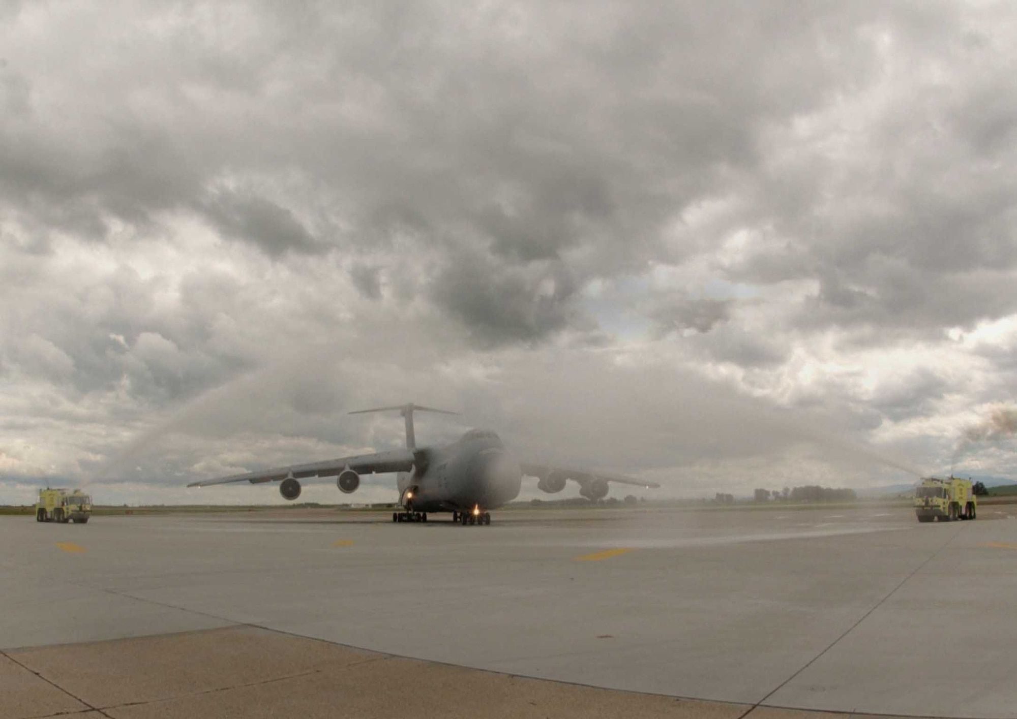 A C-5 ceremoniously taxi through a waterway arch, marking the 21st Airlift Squadron's final C-5 flight March 31. The 21st AS officially transitioned from a C-5 squadron to a C-17 squadron in a ceremony here April 3, which was also the squadron’s 64th anniversary. (U.S. Air Force photo by Airman 1st Class Tiffany Low)