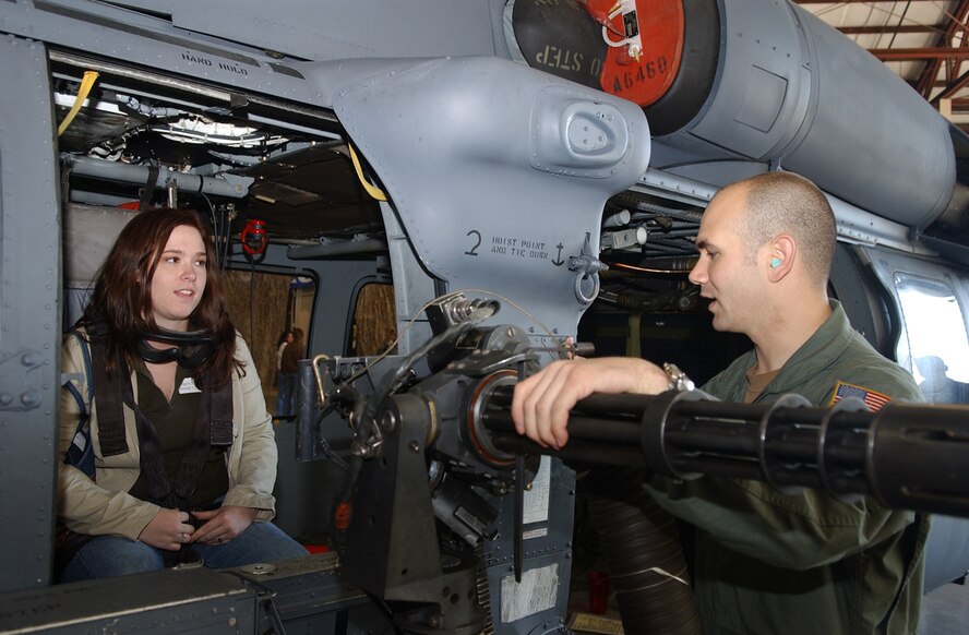 Angela Rowland, wife of Capt. Tony Rowland, 347th Aircraft Maintenance Squadron, learns about the different parts of the HH-60G Pave Hawk Saturday from Senior Airman Mike O'Neal, 41st Rescue Squadron. (Photo by Senior Airman Angelita Collins)