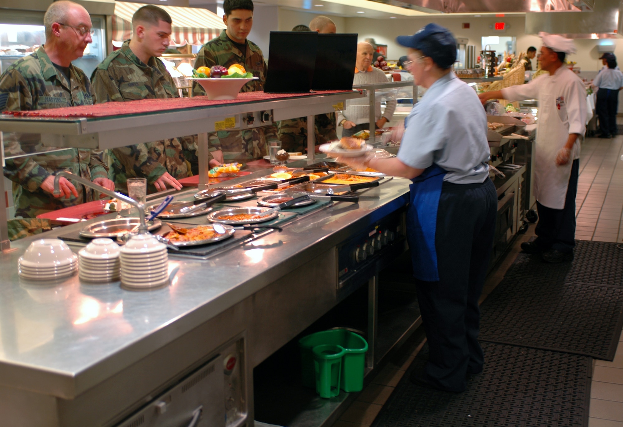 Patricia Wagner and Master Sgt. Victor Rumaroa serve customers from the “fast” line, where customers can receive items fresh off the grill along with snack-type sides such as french fries or tacos. (U.S. Air Force photo by Staff Sgt. Matthew Bates)
