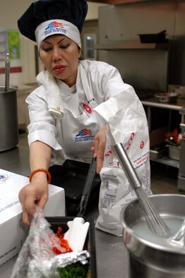Be Livingston, a cook at the Sierra Inn dining facility, gathers ingredients needed to prepare a meal during the lunchtime rush at the dining facility. (U.S. Air Force photo by Staff Sgt. Matthew Bates)