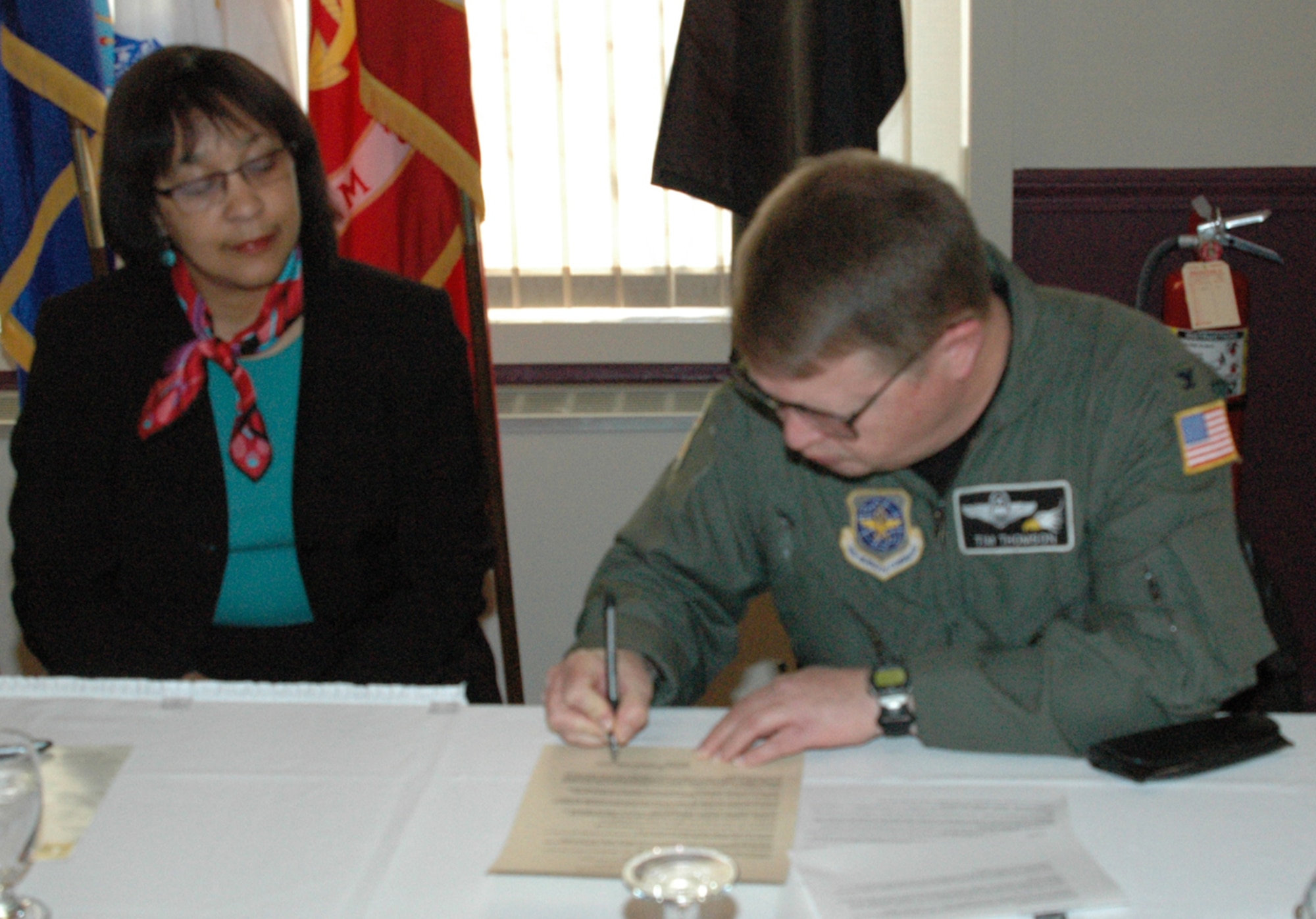 Col. Timothy J. Thomson, commander of Air Force Reserve Command's 910th Airlift Wing at Youngstown Air Reserve Station, Ohio, signs a proclamation April 6 designating April 2006 as Sexual Assault Awareness Month here.  Ms. Frances Elmore, Sexual Assault Response Coordinator (SARC) for the 910th Airlift Wing looks on.  U.S. Air Force photo/MSgt. Bryan Ripple.
