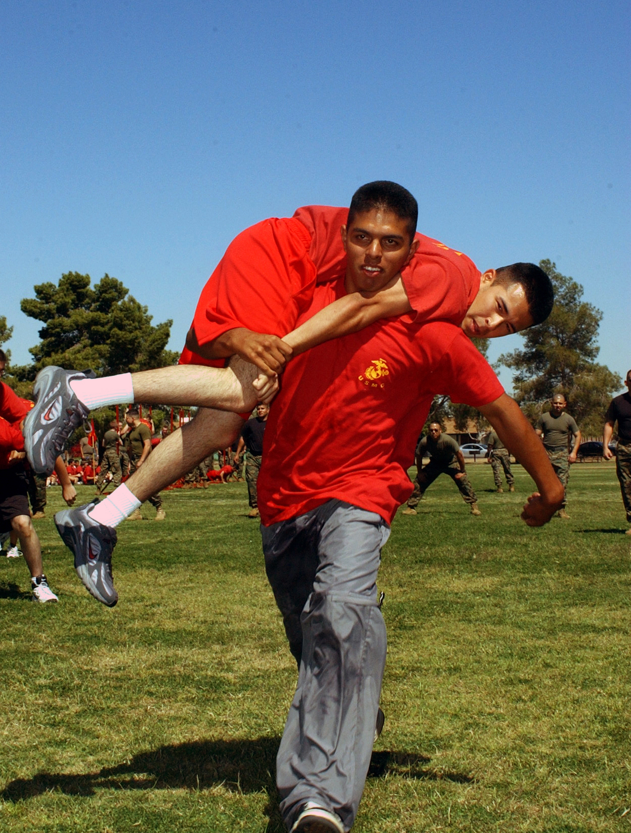 Two poolees from Recruiting Station Phoenix participate in the fireman's carry relay portion of the field meet at the RS's annual pool function.