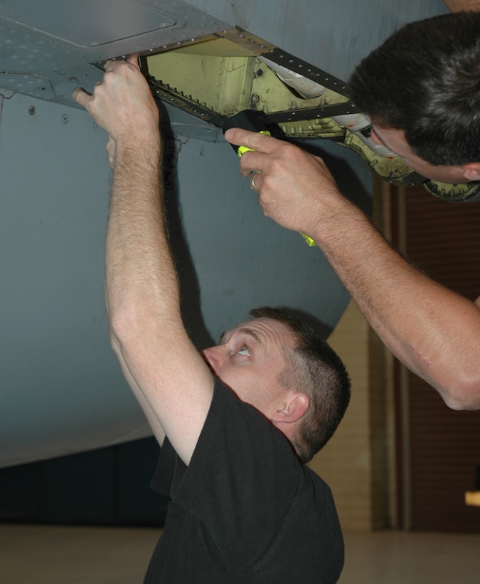 Staff Sgt. Andrew Sweeney, 944th Maintenance Squadron aircraft fuels system mechanic, works through an access door during an F-16 static display preparation process. (U.S. Air Force photo/Staff Sgt. Stephen Razo)