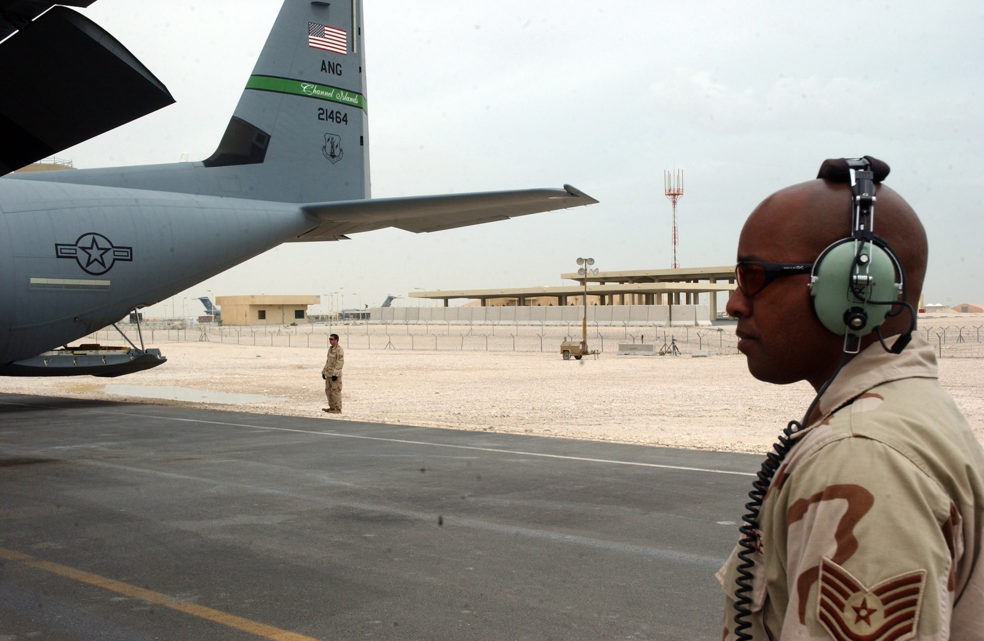 Tech. Sgt. Darrell Williams waits to marshall a C-130J Hercules on the flightline at a deployed location in Southwest Asia on Wednesday, April 5, 2006. Sergeant Williams is with the 747th Aircraft Maintenance Unit.  (U.S. Air Force photo/Senior Airman Anthony Nelson) 