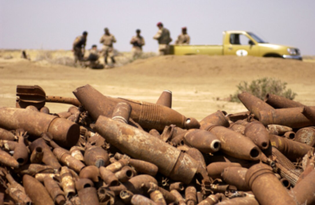 Iraqi army soldiers from the 8th Iraqi Army Division Explosive Ordnance Disposal and U.S. Navy Explosive Ordnance Disposal technicians from Multinational Division - Central South prepare to dispose of piles of unexploded ordnance in Diwaniyah, Iraq, on April 8, 2006. The demolition of the ordnance denies their use by insurgents in improvised explosive devices. 