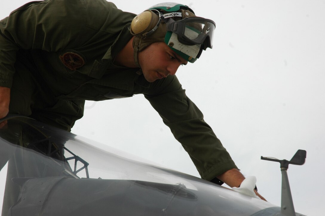 Sgt. Arthur J. Valdez, wipes down the canopy of an AV-8B Harrier, ensuring the pilot receives maximum visibility while in flight on the flight line in Al Asad, Iraq, April 11. Valdez, a fixed-wing aircraft safety equipment mechanic and native of Deming, N.M., works in Marine Attack Squadron 513, Marine Aircraft Group 16 (Reinforced), 3rd Marine Attack Wing's, ejection seat shop.