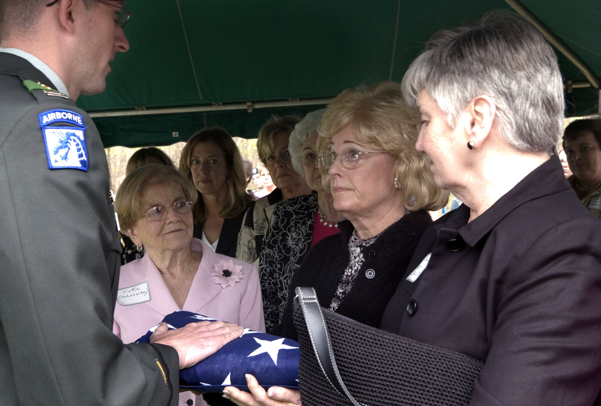 Barbara Rowland receives the flag from Capt. Rick Kimberlin on Saturday, April 8, 2006, during a memorial service for her uncle, 2nd Lt. Robert Hoyle Upchurch. The lieutenant, a member of the famed Flying Tigers during World War II, was listed as missing in action after his P-40 Warhawk crashed during bad weather.  The Upchurch family designated Ms. Rowland as the closest next of kin able to attend the ceremony.  Captain Kimberlin is assigned to Fort Bragg, N.C.  (U.S. Air Force photo/Master Sgt. Jack Braden) 