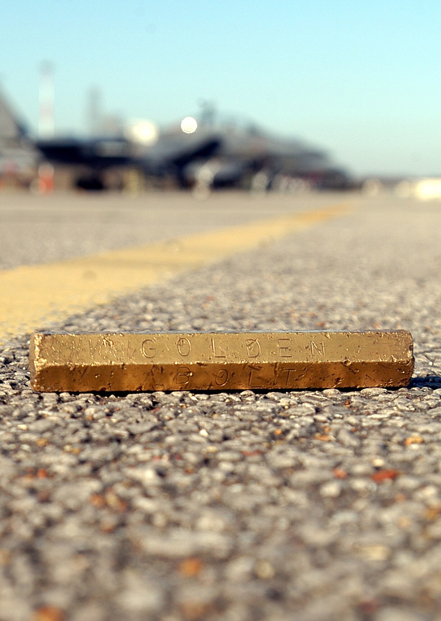 The Golden Bolt awaits discovery on the flightline at Royal Air Force Lakenheath, England. Senior aircraft maintainers place the bolt somewhere on the flightline once each month, and the finder wins prizes. The program helps improve awareness of foreign object and debris damage on the flightline.