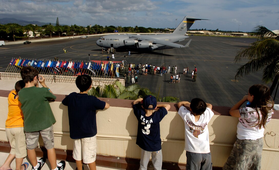 Children get a better view of the C-17 Globemaster III arrival ceremony from the roof of the operations building Saturday, April 8, 2006, at Hickam Air Force Base, Hawaii. This aircraft is the fourth C-17 to be assigned to Hickam. It will transition the 15th Airlift Wing and Hawaii Air National Guard's 154th Wing from training to operations. (U.S. Air Force photo/Tech. Sgt. Shane A. Cuomo)