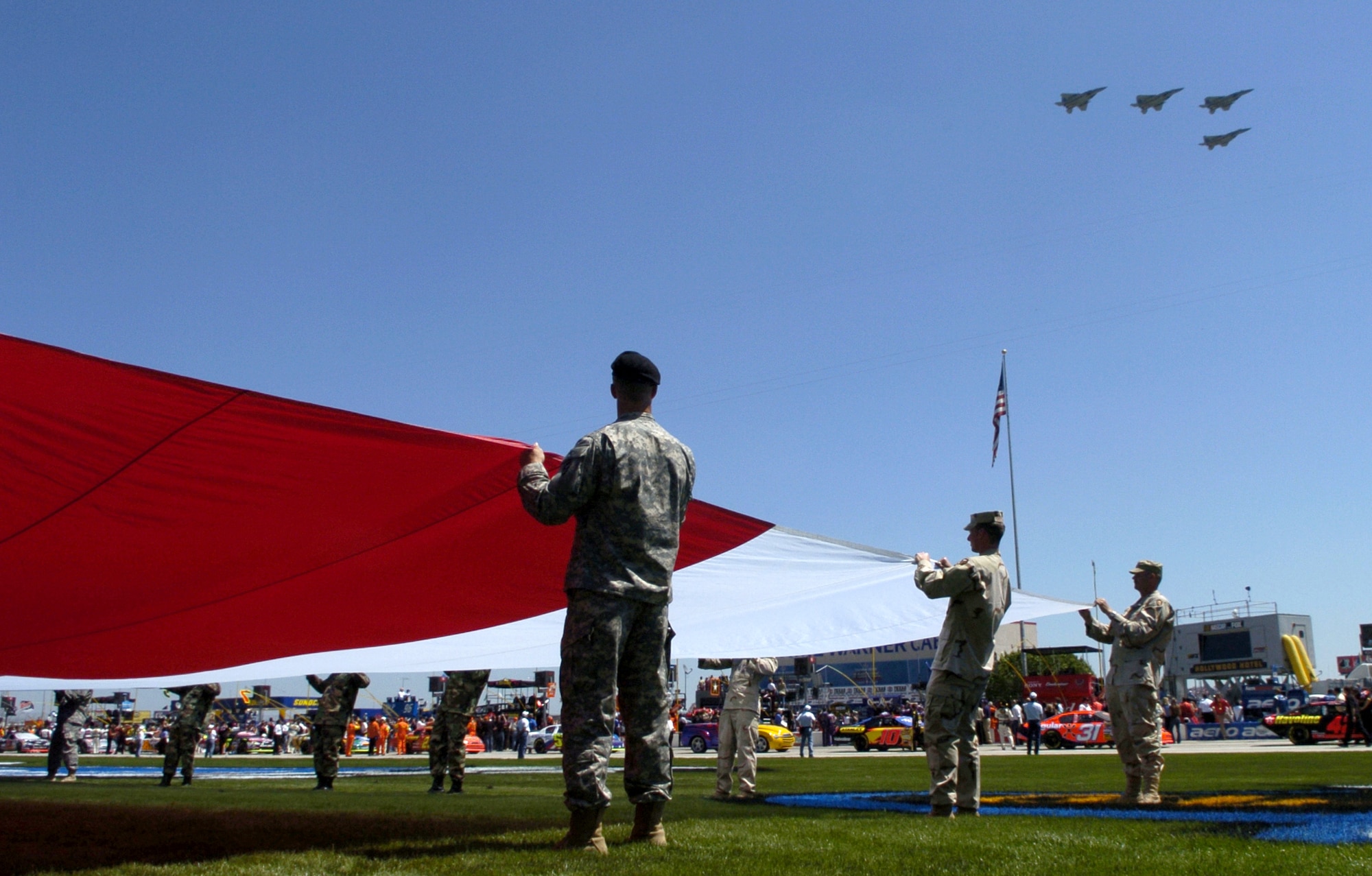 Air Force F-15 Eagles fly over the Texas Motor Speedway as a group of Texas active duty, Guard and Reserve Soldiers display the flag during the National Anthem. The flyover signaled the start of the NASCAR Nextel Cup, Samsung/RadioShack 500 on Sunday, April 9, 2006, at Texas Motor Speedway. (U.S. Air Force photo/Senior Airman Brian Ferguson) 
