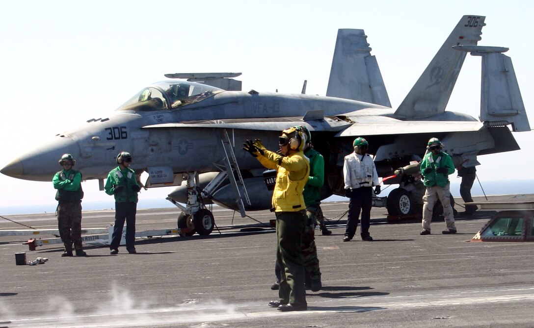 Sailors marshal an F/A-18 Hornet aircraft into position in preparation for take-off Friday, March 31, 2006, aboard the USS Ronald Reagan. F/A-18s and other aircraft are deployed with the ship to the Arabian Gulf in support of operations Iraqi Freedom and Enduring Freedom. (U.S. Air Force photo/Staff Sgt. Melissa Koskovich)