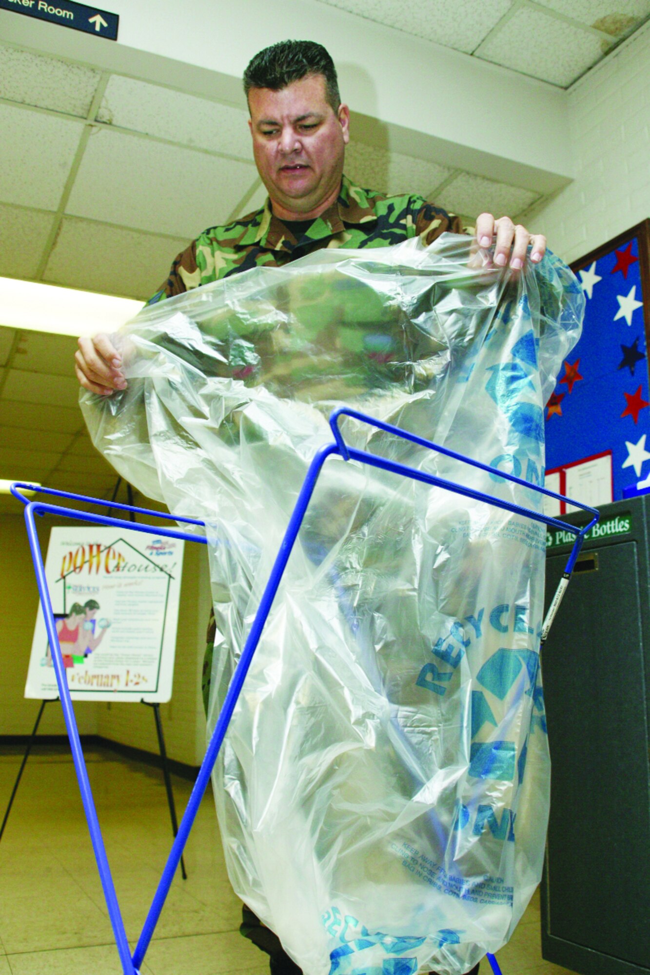 Tech. Sgt. Andy Teague, 20th Civil Engineer Squadron pollution prevention, prepares a athletic shoe recycling receptacle Feb. 2 at the fitness center.  
