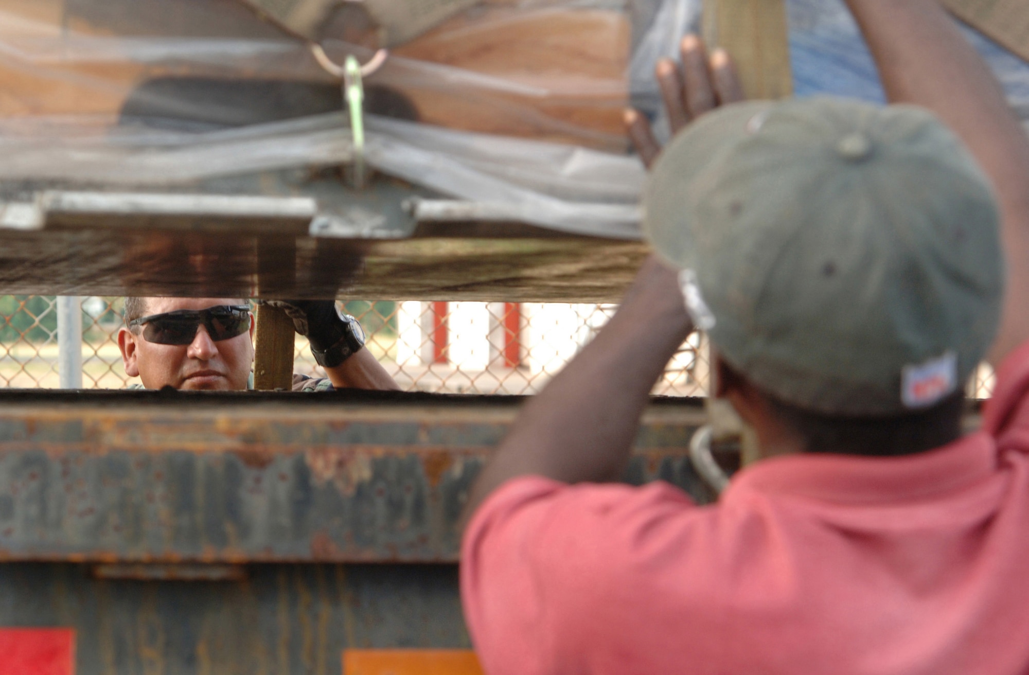 Tech. Sgt. Arthur Marin and Patrick James secure cargo on a flatbed truck on the flightline for transport Friday, April 7, 2006. The cargo is for a project which will include building an operations center and barracks for the police force supporting St. Lucia's counter-drug operations. Sergeant Marin is with the 433rd Civil Engineer Squadron at Lackland Air Force Base, Texas. Mr. James is a Saint Lucian. (U.S. Air Force photo/Tech. Sgt. Larry A. Simmons)