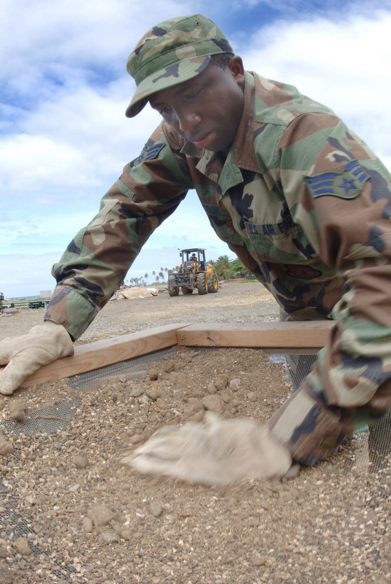 Senior Airman Julian Cook grates rocks from sand to make mortar for the Saint Lucia project on Saturday, April 8, 2006. The project includes building an operations center and barracks for the police force in support of St. Lucia's counter-drug operations. Airman Cook is with the 445th Civil Engineer Squadron at Wright-Patterson Air Force Base, Ohio. (U.S. Air Force photo/Tech. Sgt. Larry A. Simmons) 
