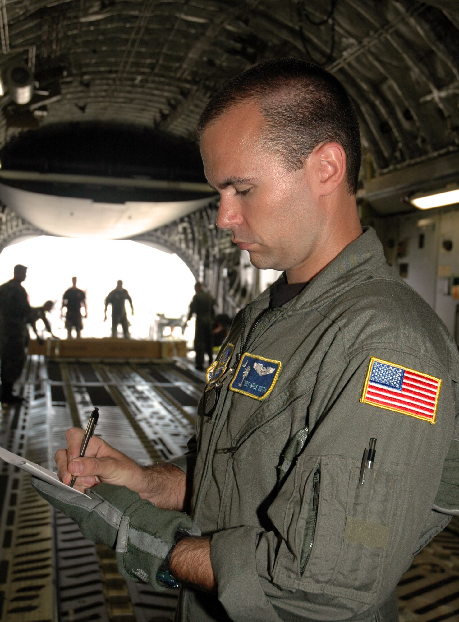 Tech. Sgt. Mike Smith, a reserve loadmaster with the 300th Airlift Squadron, Charleston AFB, S.C., checks cargo specifications aboard a C-17 Globemaster III, during a recent training mission.  (Photo by 1st Lt. Wayne Capps, USAFR)